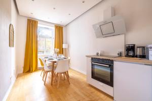 una cucina con un tavolo con sedie e una stufa di Maisonette Rustic Altstadt zentral-Wlan-Parkplatz a Erfurt Altre 26 foto