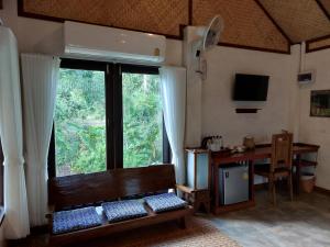 a room with a bench and a desk and a window at เวียงปันดาว Viengpundao เชียงดาว in Ban Tham