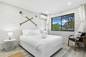 Un dormitorio blanco con una cama grande y una ventana en Oceanview on Dudley, en Woodgate