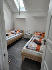 twee bedden in een kleine kamer met een raam bij Nagyi Apartman Kecskemét in Kecskemét