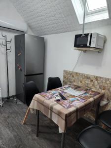 Habitación con mesa con sillas y TV. en Nagyi Apartman Kecskemét, en Kecskemét