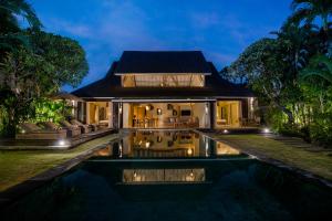 a villa with a swimming pool at night at Space Villas Bali in Seminyak