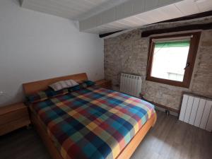 1 dormitorio con 1 cama en una habitación con ventana en CA L'ENGRÀCIA, en Tarrés