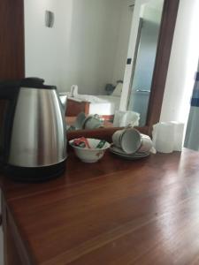 Negombo Royal Villa by Hotel Oviniru في نيجومبو: طاولة مع وعاء القهوة وأطباق عليها
