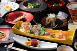 una mesa cubierta con platos de comida y bebida en Hanare Yado Yoshizumi, en Izu