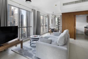 - un salon avec un canapé et une télévision dans l'établissement Class Home-Superb 1BR apartment with full Burj Khalifa View-5min walk to Dubai Mall, à Dubaï