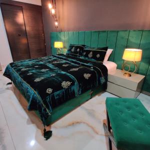 a bedroom with a large bed with a green headboard at Elite,16 Bedrooms 16 bath Block 6 Gulshan-e-iqbal in Karachi