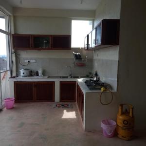 una cocina con fregadero y estufa en Nipuni Sky Inn, en Nuwara Eliya
