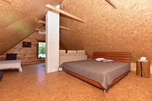 a bedroom with a bed and a couch in a room at Pundeliškių sodyba in Skynimai