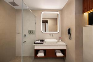 a bathroom with a sink and a mirror at jüSTa Hollow Oak, Mussoorie in Mussoorie