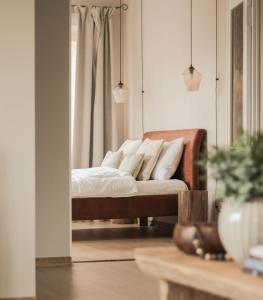 a bedroom with a bed with white pillows on it at Upės apartamentai II su baseinu ir kiemeliu in Anykščiai