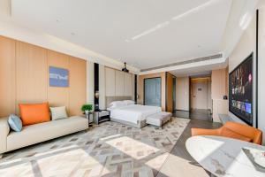a hotel room with two beds and a flat screen tv at Elephant Hotel in Zhuhai