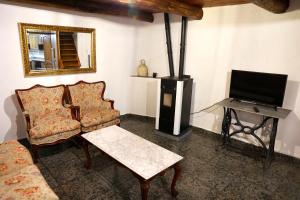 A CASA DO POZO في Folgoso: غرفة معيشة مع أريكة وتلفزيون وكرسي