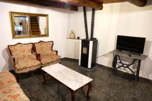 a living room with a couch and a tv and a chair at A casa do pozo - AS CASAS DO POZO - in Folgoso