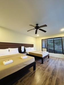 a bedroom with two beds and a ceiling fan at Sheridan Organic Farm and Eco Village in Maratapi