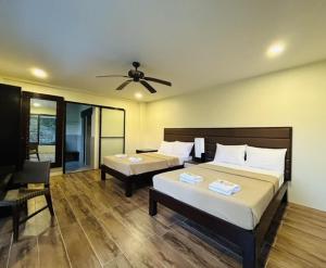 a bedroom with two beds and a ceiling fan at Sheridan Organic Farm and Resort in Maratapi +28 photos