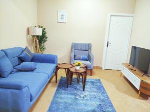 a living room with a blue couch and a table at Moon Homes in Cairo