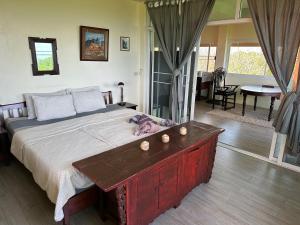 a bedroom with a large bed with a wooden table at Koh Mak Penthouse in Ko Mak