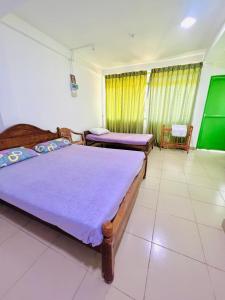 1 dormitorio con 2 camas y una pantalla verde en Touch Down Family Restaurant & hotel en Katunayaka