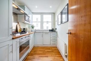 cocina con armarios blancos y ventana grande en Location Trafalgar Square 1 Bedr, 3 Beds, sleeps 6, en Londres
