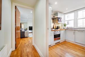 cocina con armarios blancos y suelo de madera dura en Location Trafalgar Square 1 Bedr, 3 Beds, sleeps 6, en Londres