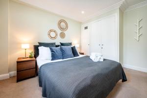 a bedroom with a large bed with blue pillows at Location Trafalgar Square 1 Bedr, 3 Beds, sleeps 6 in London