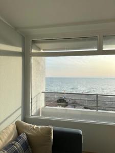 a living room with a window looking out at the ocean at Strandhotel Wohnung 69 in Dahme