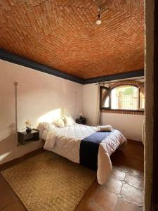 a bedroom with a large bed with a wooden ceiling at Casa Orquidea in San Miguel de Allende