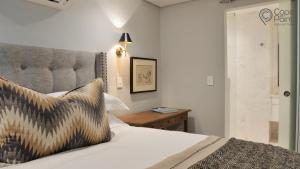 - une chambre avec un lit avec une tête de lit et une table dans l'établissement Luxury apartments - Greenpoint - 35 on Main, au Cap