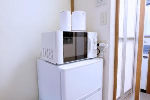 a microwave sitting on top of a refrigerator at green park heights - Vacation STAY 15683 in Musashino