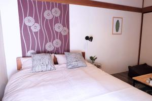 Dormitorio con cama con estampado de flores en la pared en green park heights - Vacation STAY 15683 en Musashino