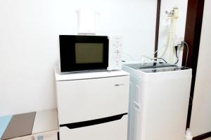 a microwave sitting on top of a white refrigerator at green park heights - Vacation STAY 15684 in Musashino