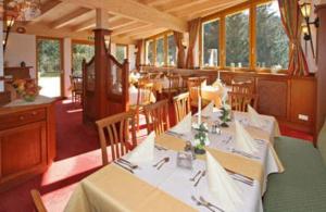 une salle à manger avec une table et des nappes blanches dans l'établissement Hotel Berghof, à Söll