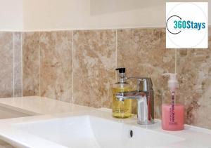 a bathroom sink with a bottle of soap and a soap dispenser at Luxury 1 Bedroom Apartment 06 with Parking in Maidenhead by 360stays in Maidenhead