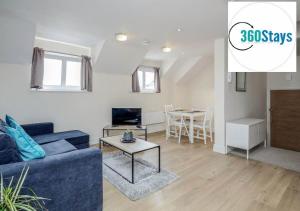 a living room with a blue couch and a table at Luxury 1 Bedroom Apartment 06 with Parking in Maidenhead by 360stays in Maidenhead