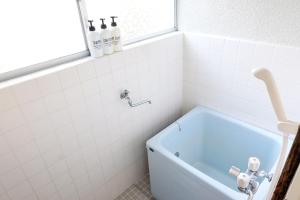 een badkamer met een blauw bad en een raam bij green park heights - Vacation STAY 15687 in Musashino
