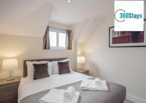 Luxury 1 Bedroom Apartment 06 with Parking in Maidenhead by 360stays في ميدينهيد: غرفة نوم عليها سرير وفوط