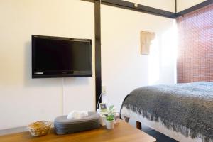 um quarto com uma cama e uma televisão de ecrã plano em green park heights - Vacation STAY 15687 em Musashino