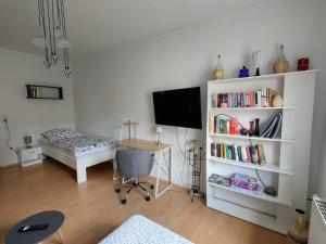 een woonkamer met een bureau en een televisie bij Green Oelsnitz am Hegebach mit Netflix und Parkplatz Self Check-in in Oelsnitz