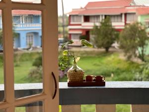 einen Tisch mit einer Vase auf einem Fensterbrett in der Unterkunft Chalet Saffron Goa in Benaulim