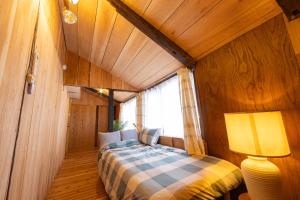 a bedroom with a bed in a room with a window at Guest House Henza in Henza