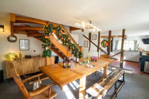a dining room with a wooden table and stairs at Prospect Place by UK Vacations in Westleton