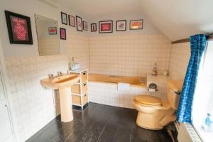 a bathroom with a sink and a toilet and a tub at Prospect Place by UK Vacations in Westleton