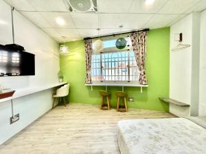 小琉球的住宿－宿室唷，一间设有绿色墙壁和两张凳子的房间