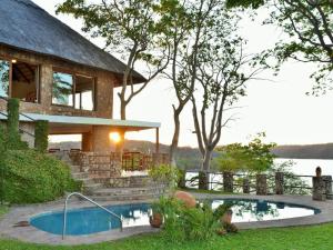 Binga的住宿－Masumu River Lodge，庭院中带游泳池的房子