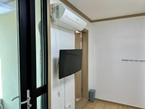 Habitación con TV de pantalla plana en la pared en Fullhouse 6TO10, en Gangneung