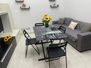 a living room with a table with chairs and a couch at G&M Home in Castellana Grotte