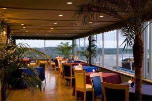 a restaurant with tables and chairs and large windows at Zekkeino Yado Inubohsaki Hotel in Choshi