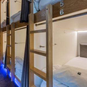 UAE Capsule Hostel 5 min Walkable from Sharaf DG Metro في دبي: سرير بطابقين مع سلم في الغرفة