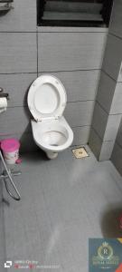 - une salle de bains avec des toilettes blanches dans une cabine dans l'établissement Royal Suites, à Pune